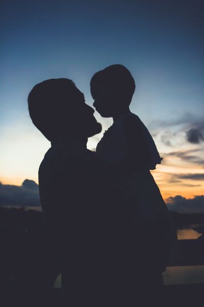 silhouette of man holding a child